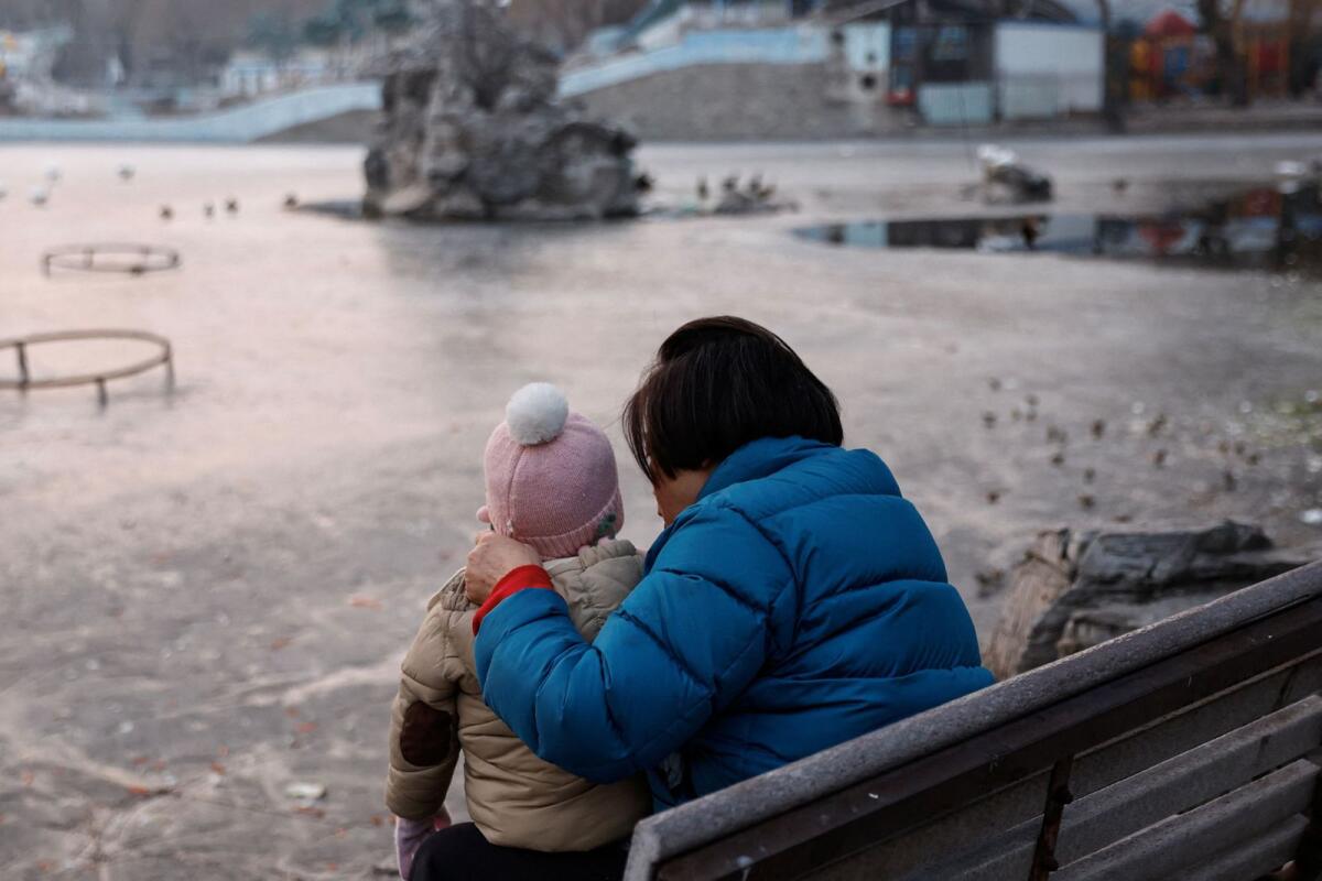 A woman and a child sit in a park in Beijing, China, on January 12, 2024. — Reuters