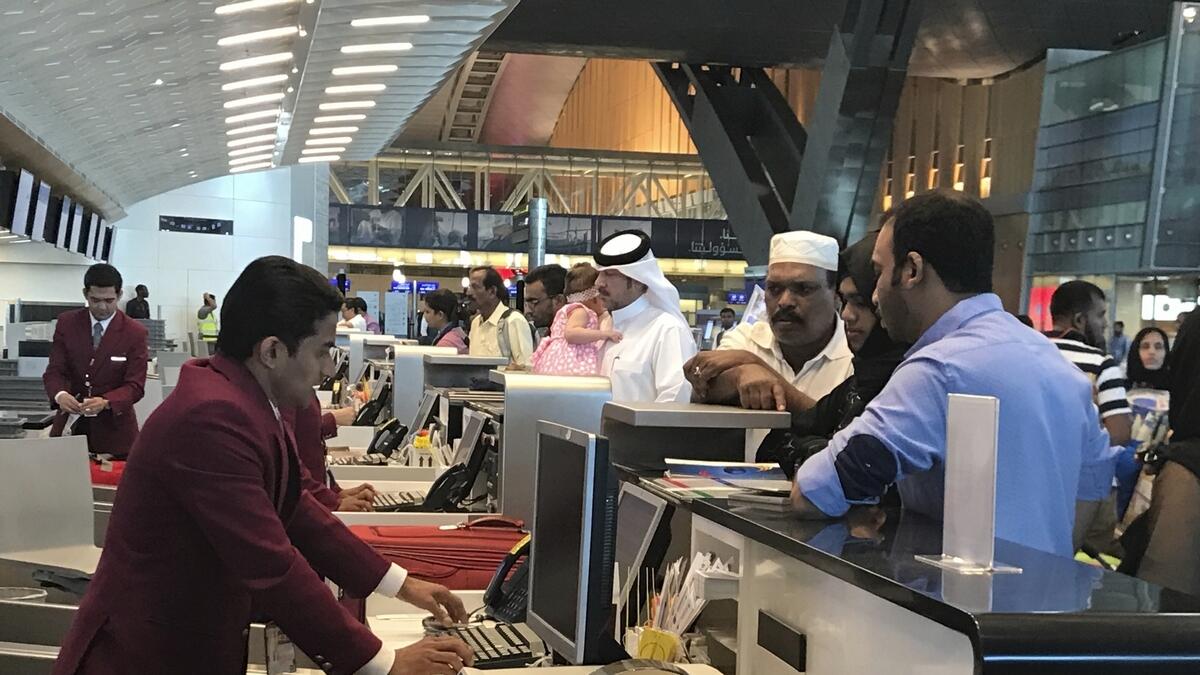 Qatari and other nationals queue at the check in counters of the Hamad International Airport in Doha, Qatar