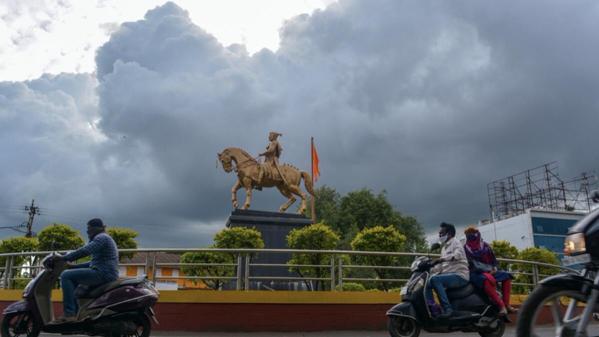 Dark clouds covering the sky loom over a statue of Chhatrapati Shivaji Maharaj, in Karad, India. Photo: PTI