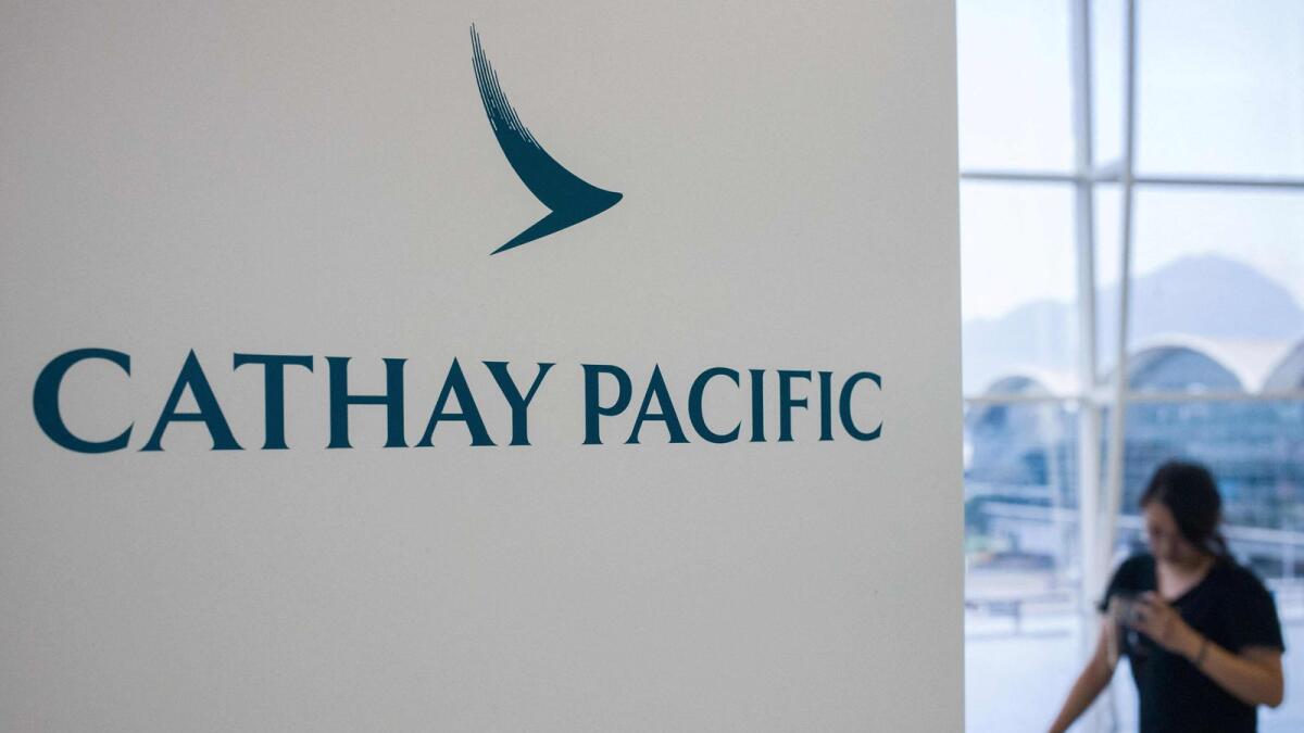 A woman walking past a Cathay Pacific Airways sign at Hong Kong's international airport. Hong Kong carrier Cathay Pacific said on March 10, 2021 it suffered a $2.8 billion loss in 2020 as the coronavirus pandemic hammered its business. — AFP