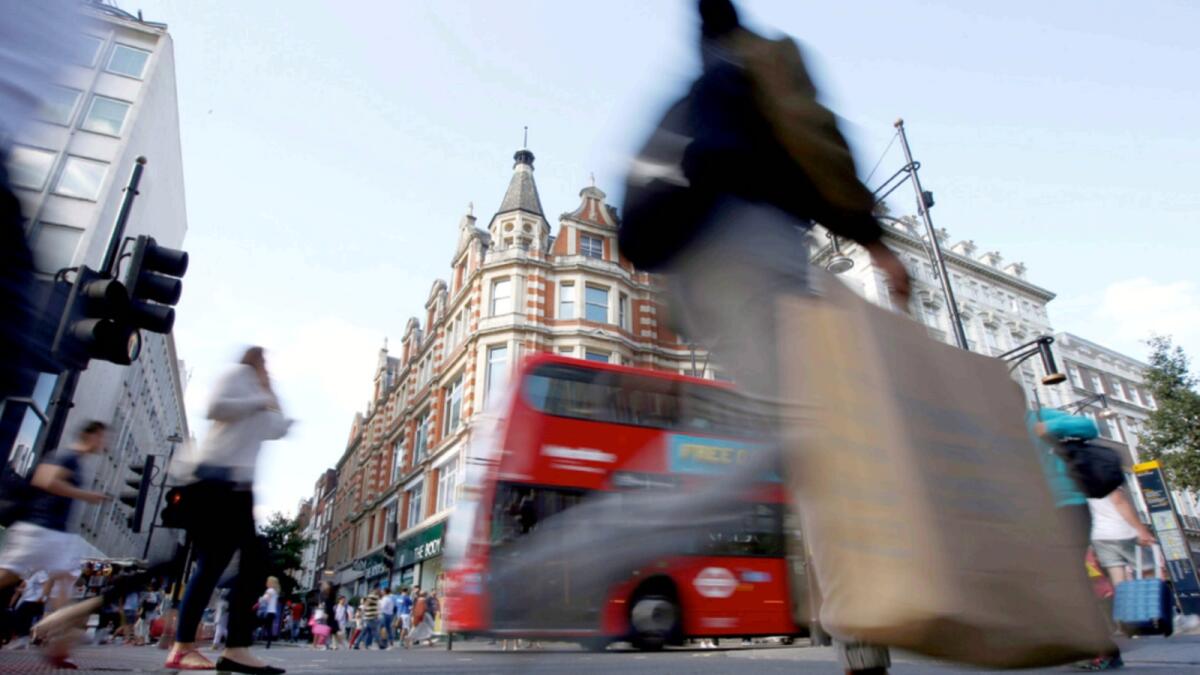 Shoppers cross the road in Oxford Street, in London. — Reuters file