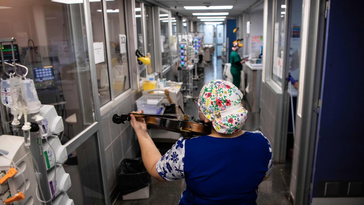 Chilean nurse Damaris Silva plays the violin for patients infected with Covid-19, at the Intensive Care Unit of the El Pino hospital, in Santiago, Chile. Photo: AFP