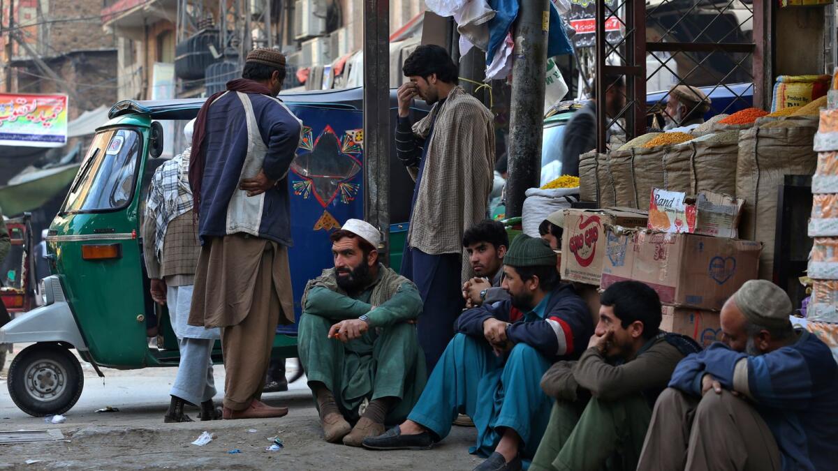 Daily wage labourers wait for work at a market in Peshawar, Pakistan. — AP