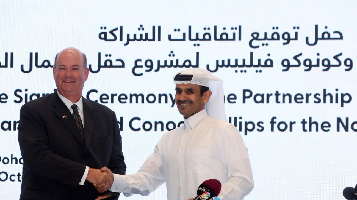 Qatar's Minister of State for Energy Affairs and president and CEO of QatarEnergy Saad Sherida Al Kaabi and Ryan Lance, CEO of American multinational corporation ConocoPhillips, shake hands after signing an agreement at the QatarEnergy headquarters in Doha on October 30, 2022.  — AFP