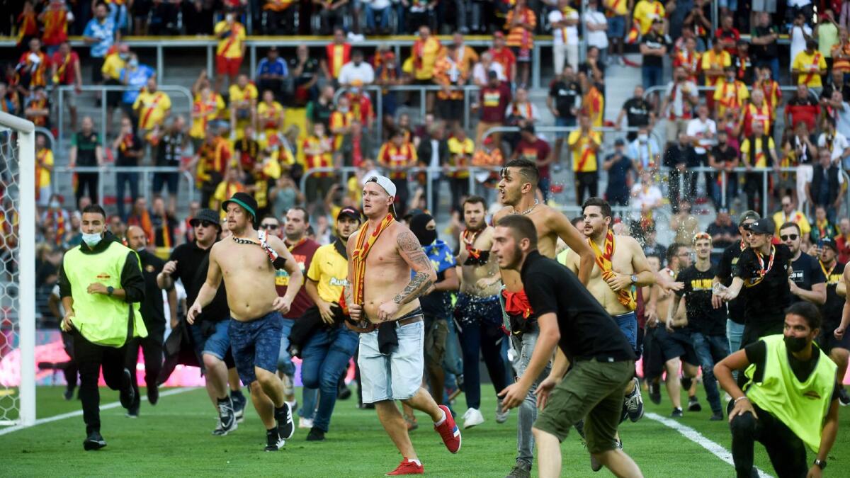 Lens' supporters invade the pitch during the French L1 match against RC Lens. — AFP