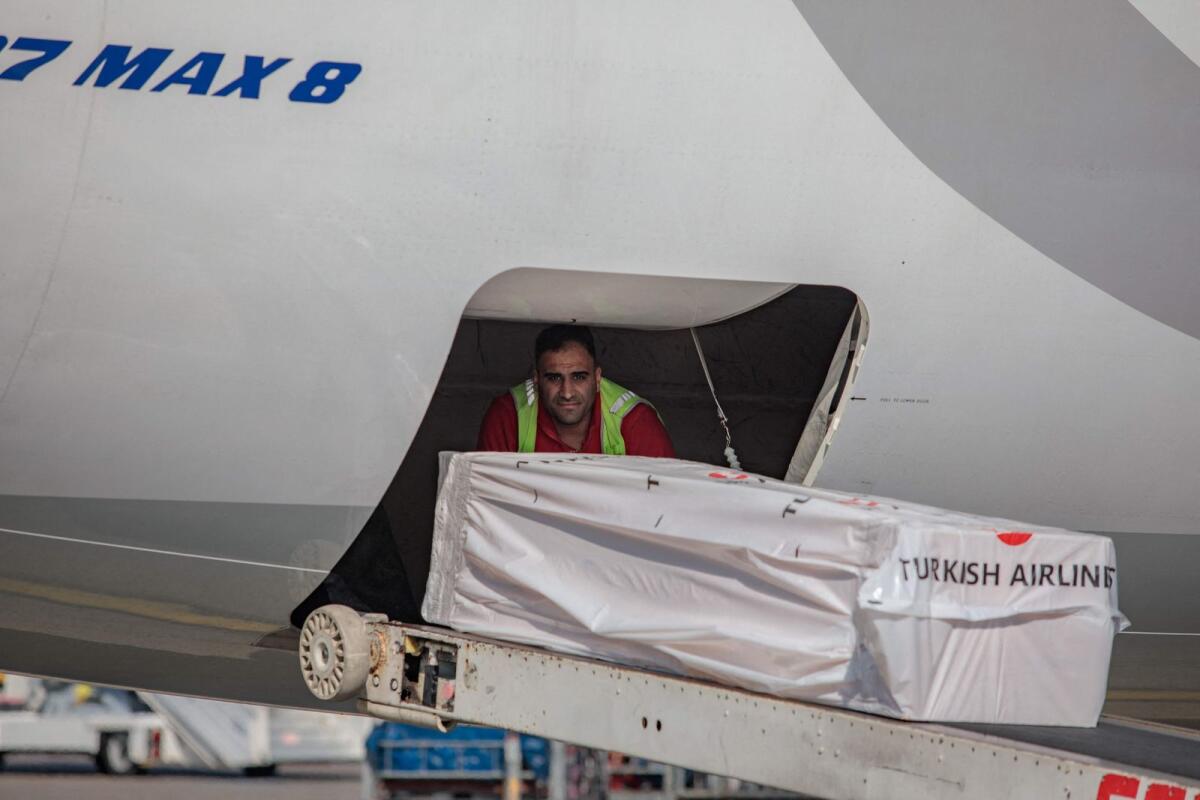 The coffin containing the body of Christian Atsu is loaded into an airplane bound for Ghana, at Adana airport in southern Turkey. — AFP