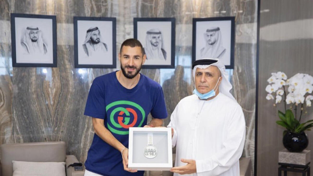 Mattar Mohammed Al Tayer presents the medal to Karim Benzema.
