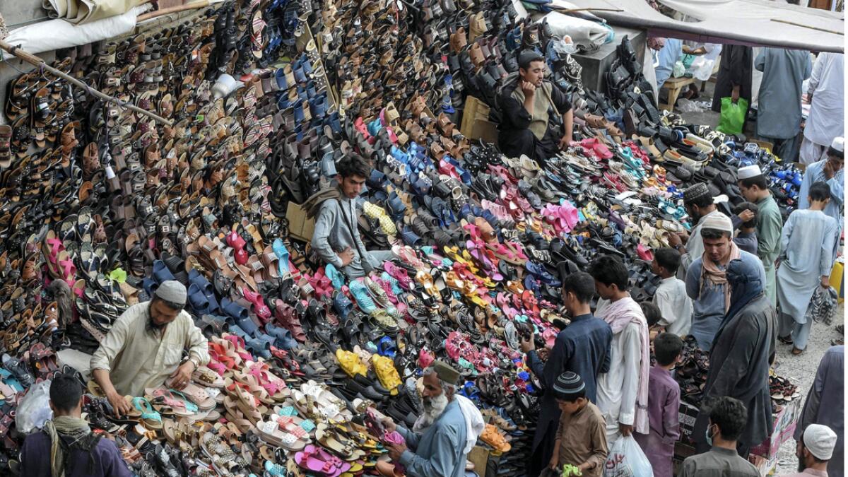 Customers shop at shoe stalls on a street ahead of Eid Al Adha or the 'Festival of Sacrifice', in Quetta, Pakistan.  Photo: AFP