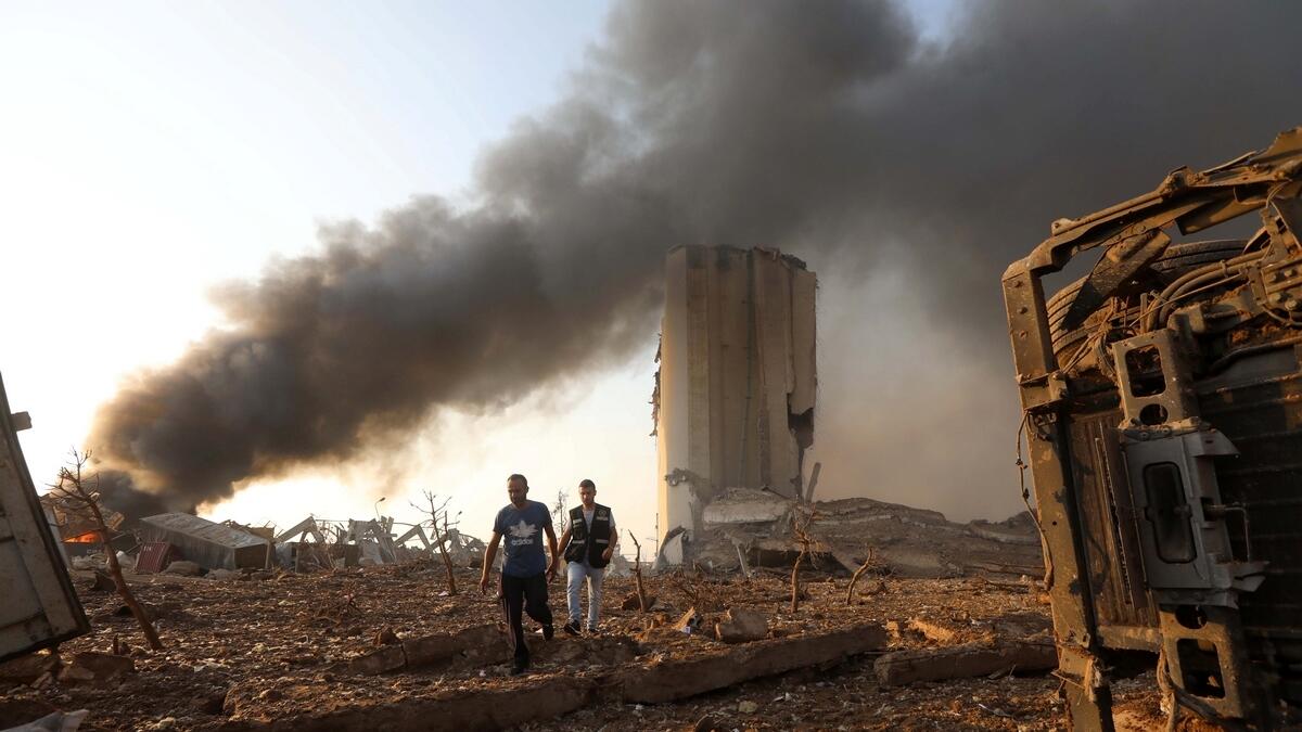 Men walk at the site of an explosion in Beirut. Reuters