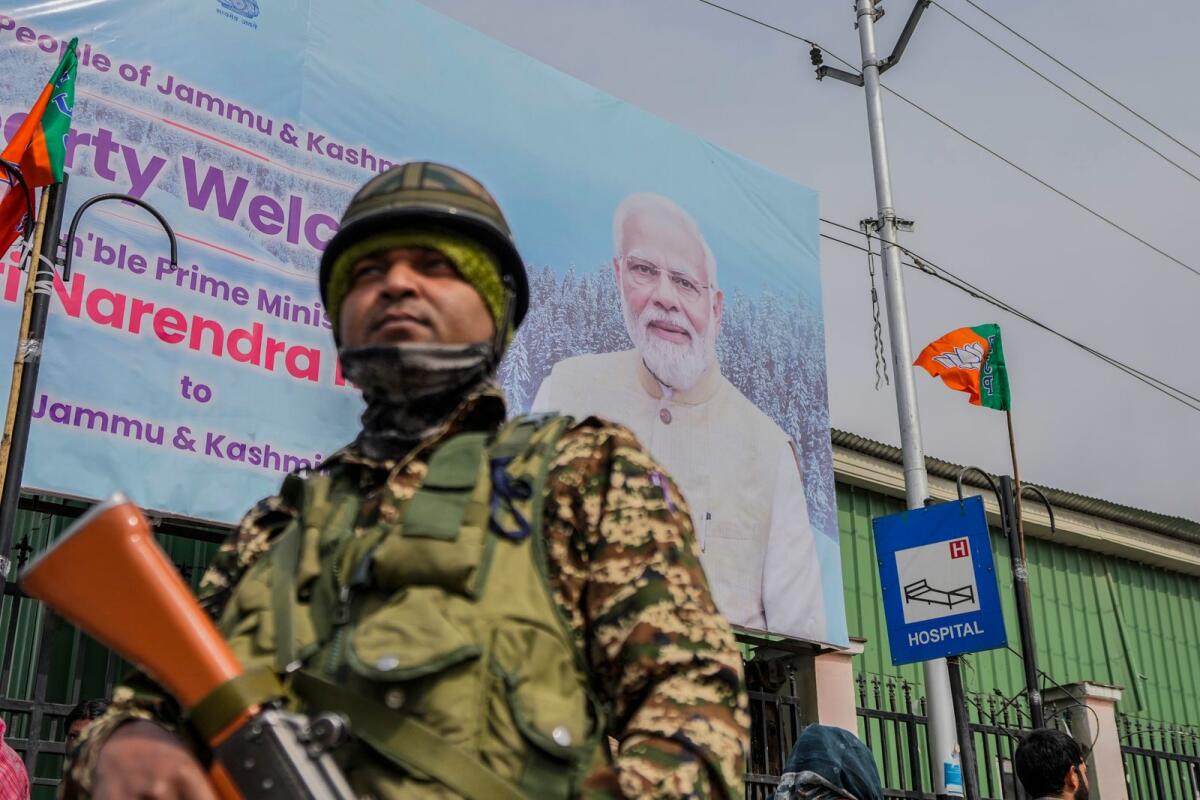 A paramilitary soldier guards near a billboard ahead of Indian Prime Minister Narendra Modi's visit to Srinagar. Photo: AP