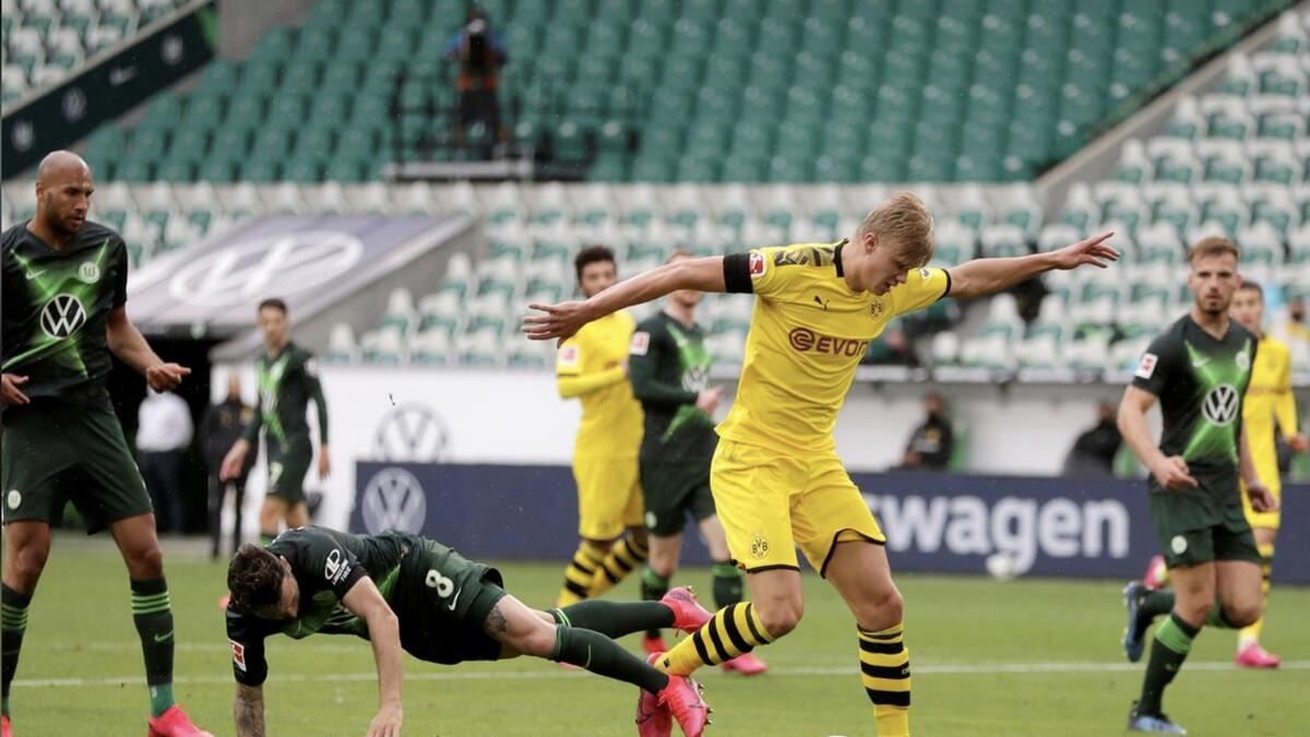 Borussia Dortmund's Erling Haaland in action with VfL Wolfsburg's Renato Steffen jn the Bundesliga on Saturday. - Reuters