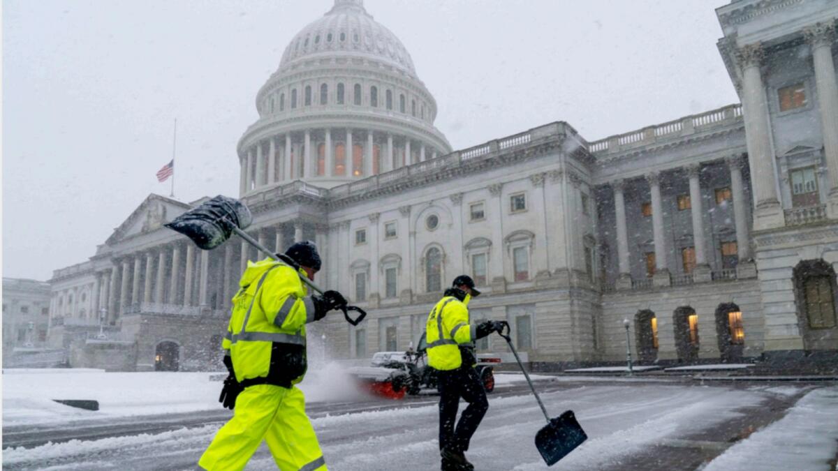 Workers clear the East Plaza of the Capitol as a winter storm delivers heavy snow to Washington. — AP