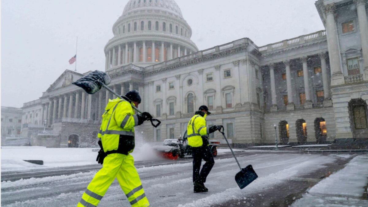 Workers clear the East Plaza of the Capitol as a winter storm delivers heavy snow to Washington. — AP