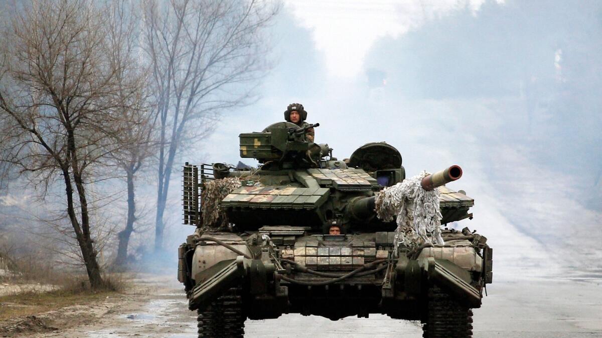 Ukrainian servicemen ride on tanks towards the front line with Russian forces in the Lugansk region of Ukraine on February 25, 2022. Photo: AFP