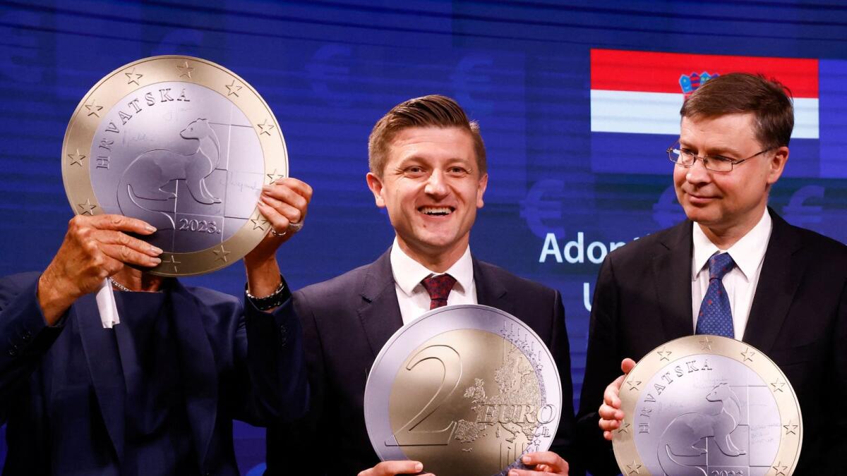 Croatia's Finance Minister Marko Primorac, European Commissioner vice-president Valdis Dombrovskis and President of European Central Bank Christine Lagarde pose with a model of a Euro coin. -Reuters