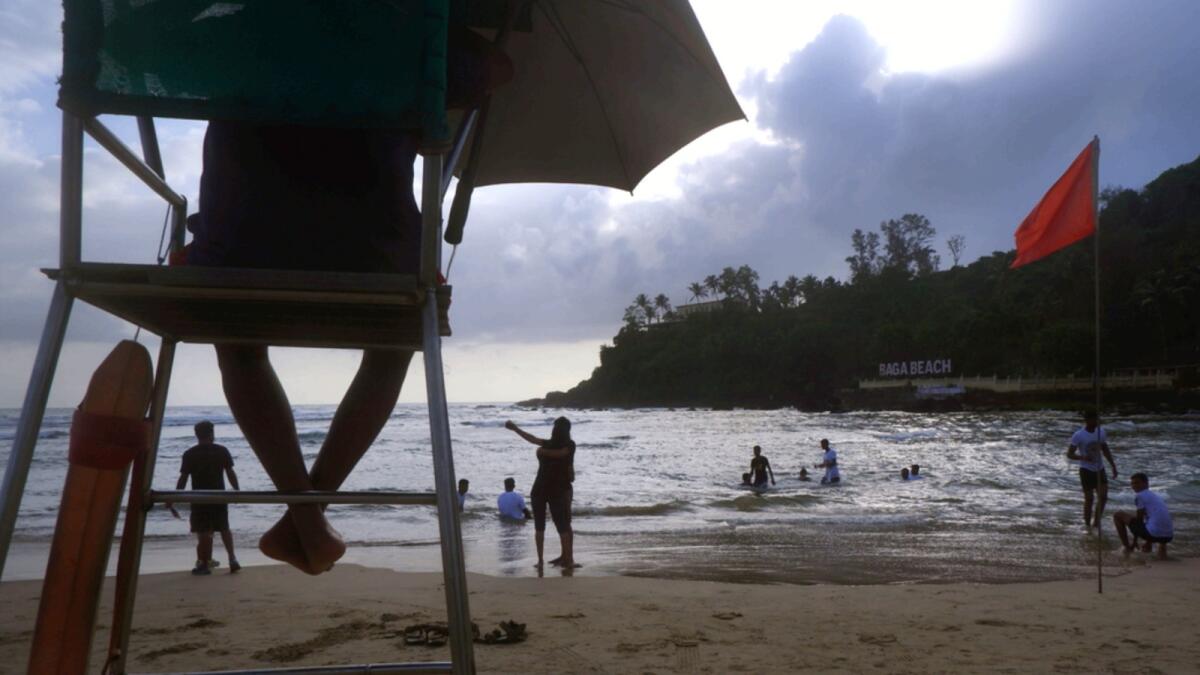 A lifeguard keeps watch as Indian tourists spend the evening on a beach in Goa. — AP file