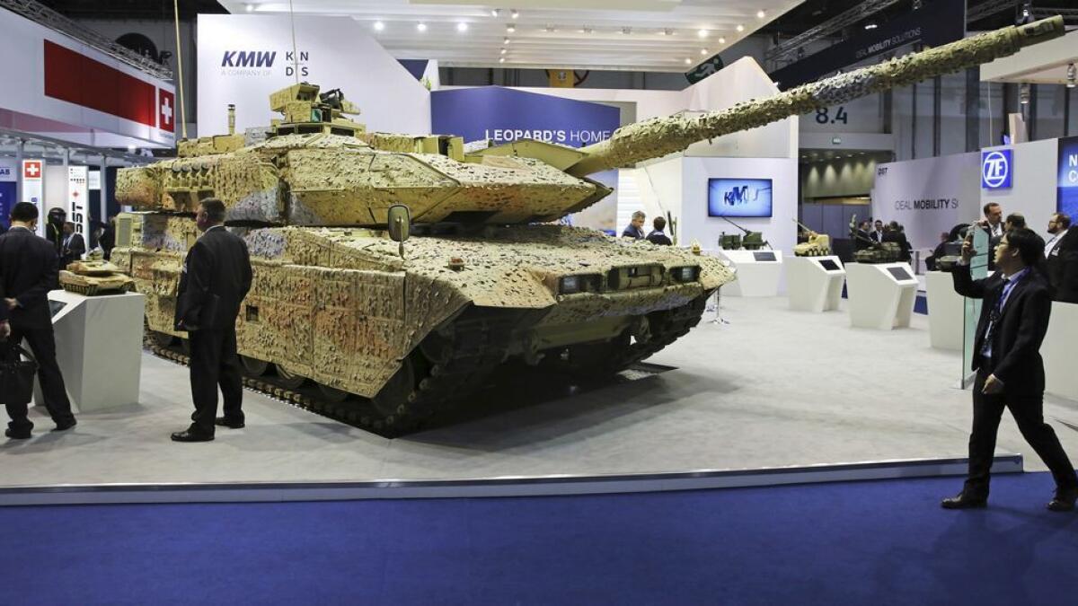 A man takes a photograph of a Krauss-Maffei Wegmann Leopard tank at the International Defense Exhibition and Conference in Abu Dhabi.
