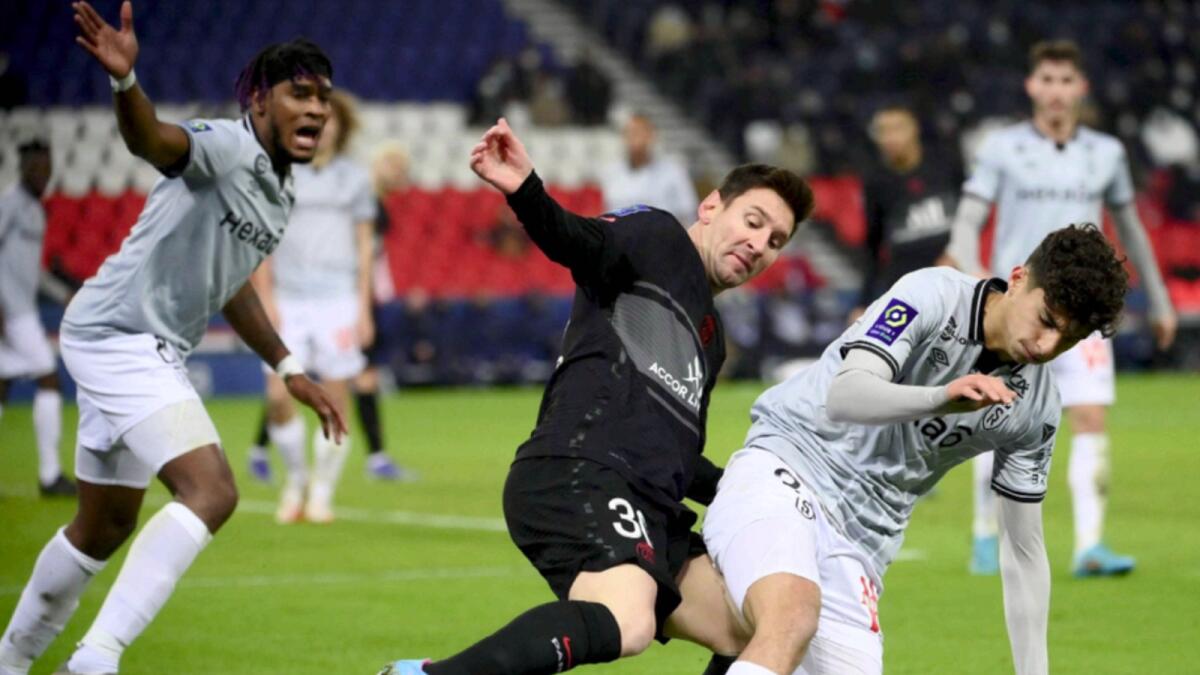 Lionel Messi fights for the ball with Reims' French midfielder Martin Adeline during the French L1 football match between PSG and Reims. — AFP