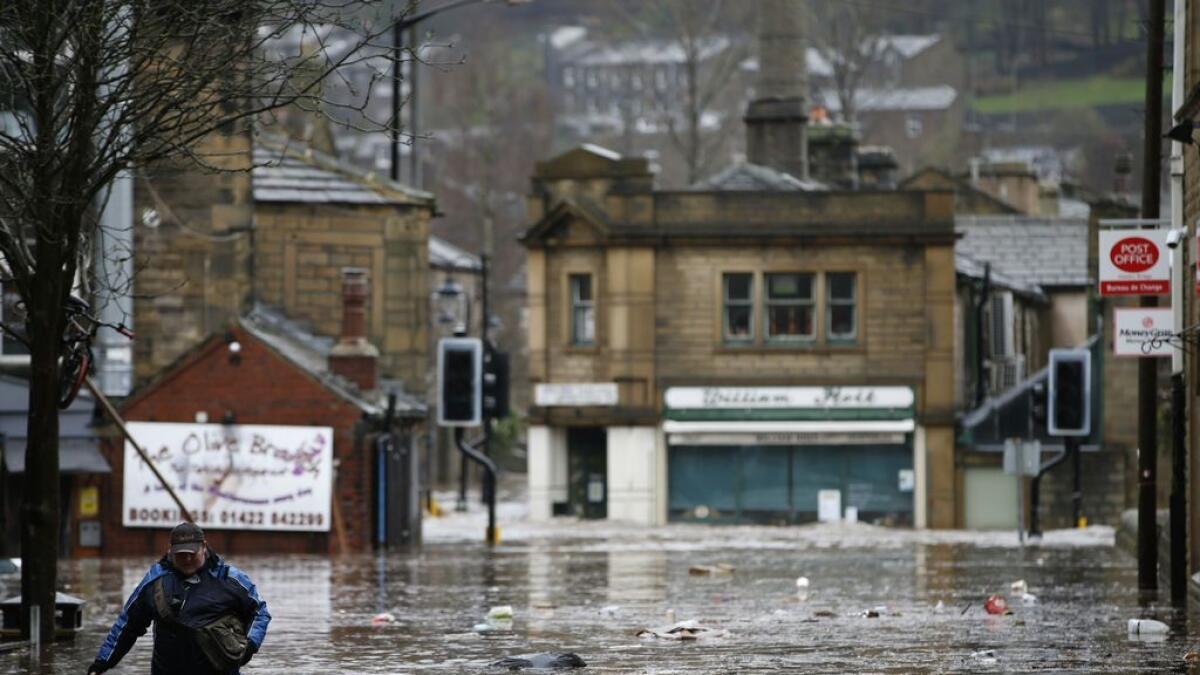 A man wades through flood waters at Hebden Bridge in West Yorkshire, England.