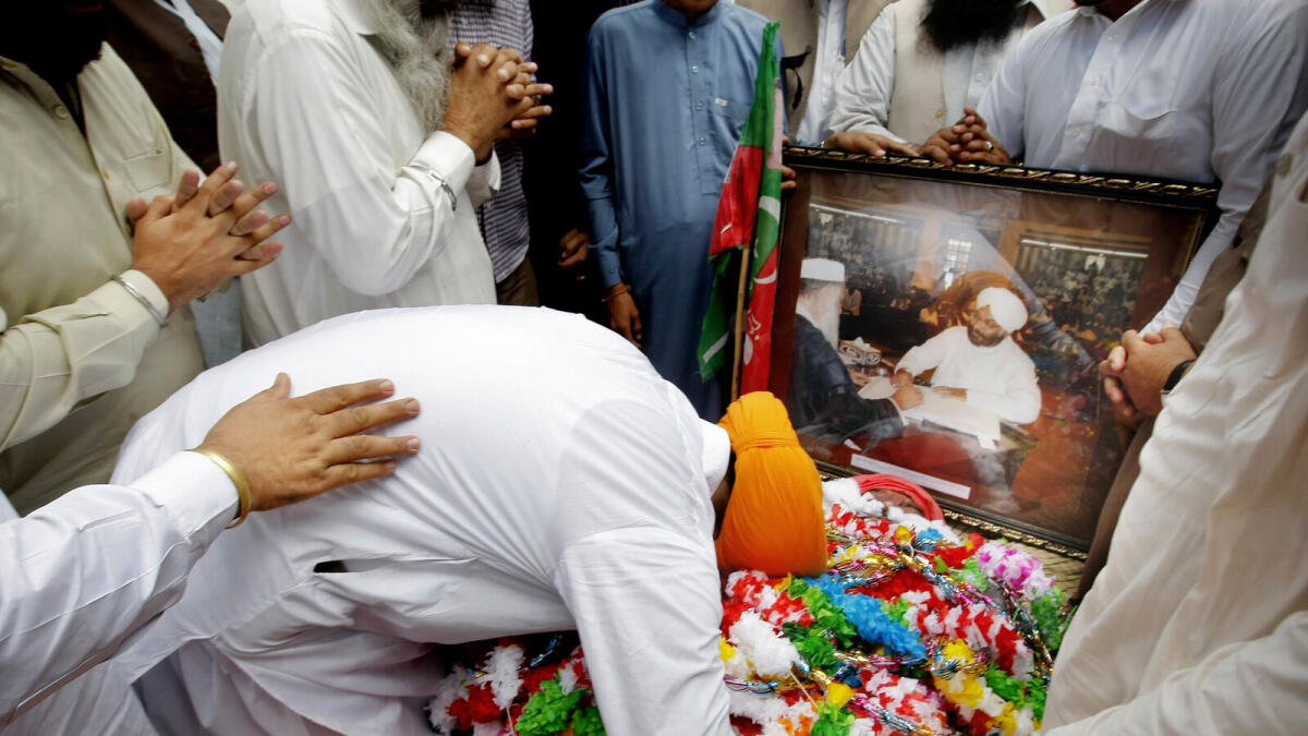In this Saturday, April 23, 2016 photo, People mourn during the funeral of Pakistani Sikh lawmaker Sardar Suran Singh in Buner, Pakistan.