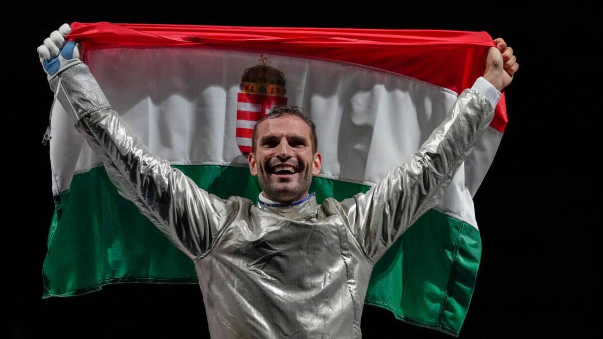 Aron Szilagyi of Hungary celebrates with his national flag after winning the gold in the men's individual final Sabre competition. — AP