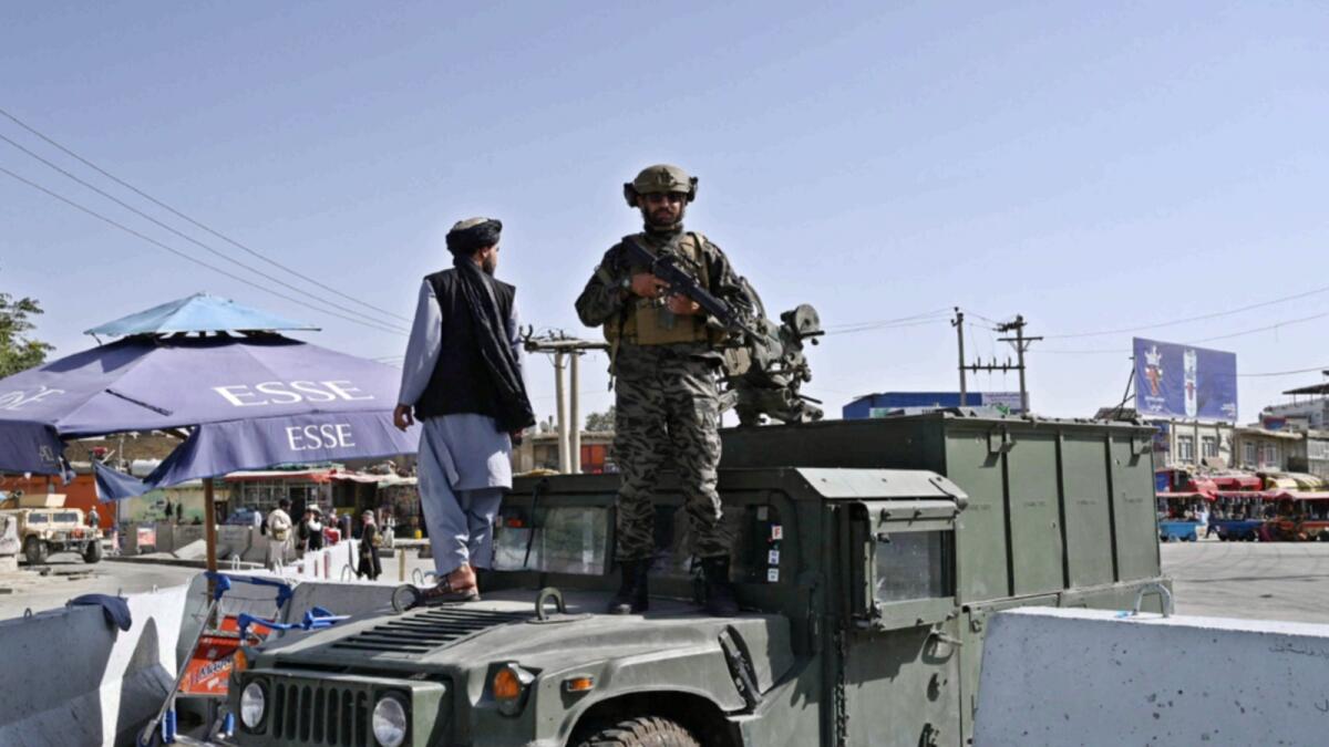 A Taliban Badri fighter, a special forces unit, stands guard on Humvee vehicle at the main entrance gate of Kabul airport. — AFP