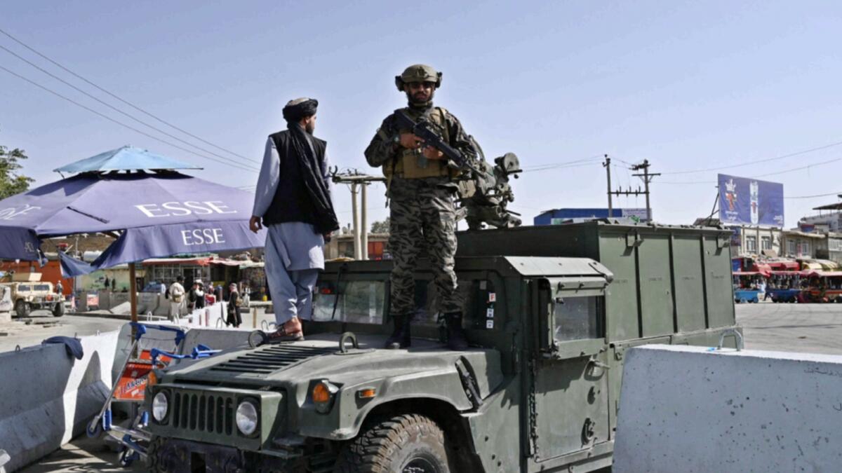 A Taliban Badri fighter, a special forces unit, stands guard on Humvee vehicle at the main entrance gate of Kabul airport. — AFP
