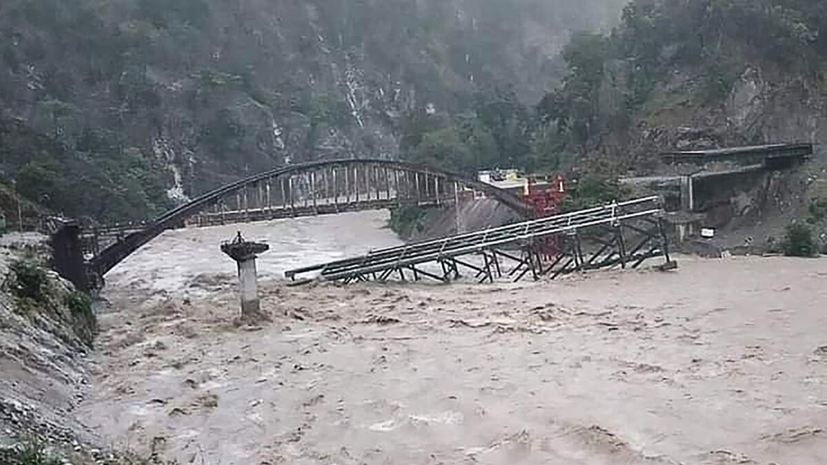 A bridge is seen collapsing on a river along a national highway between Pithoragarh-Champawat, in Chalthi following heavy rainfalls in northern India. – AFP
