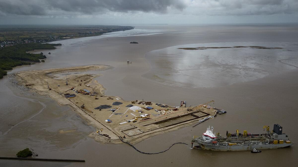 A ship creates an artificial island by extracting offshore sand to create a coastal port for offshore oil production at the mouth of the Demerara River in Georgetown, Guyana. Guyana is poised to become the world’s fourth-largest offshore oil producer, placing it ahead of Qatar, the United States, Mexico and Norway. — AP