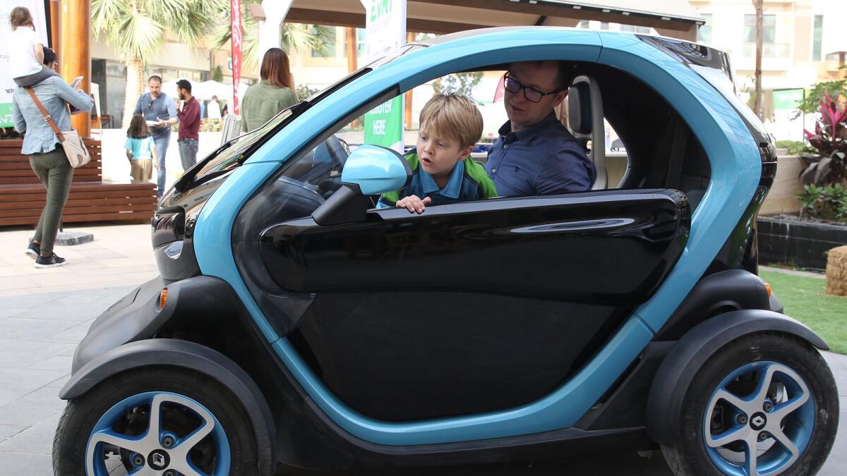 Michal Ocwieja with his son Denis checking an electric car Renault Twizy at the Grand Finale of the Electric Vehicle Road Trip Middle East at The Sustainable City in Dubai. -- File photo