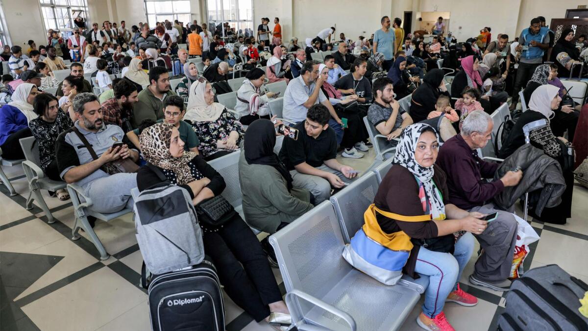 People sit in the waiting area at the Rafah border crossing in the southern Gaza Strip before crossing into Egypt on November 1. — AFP