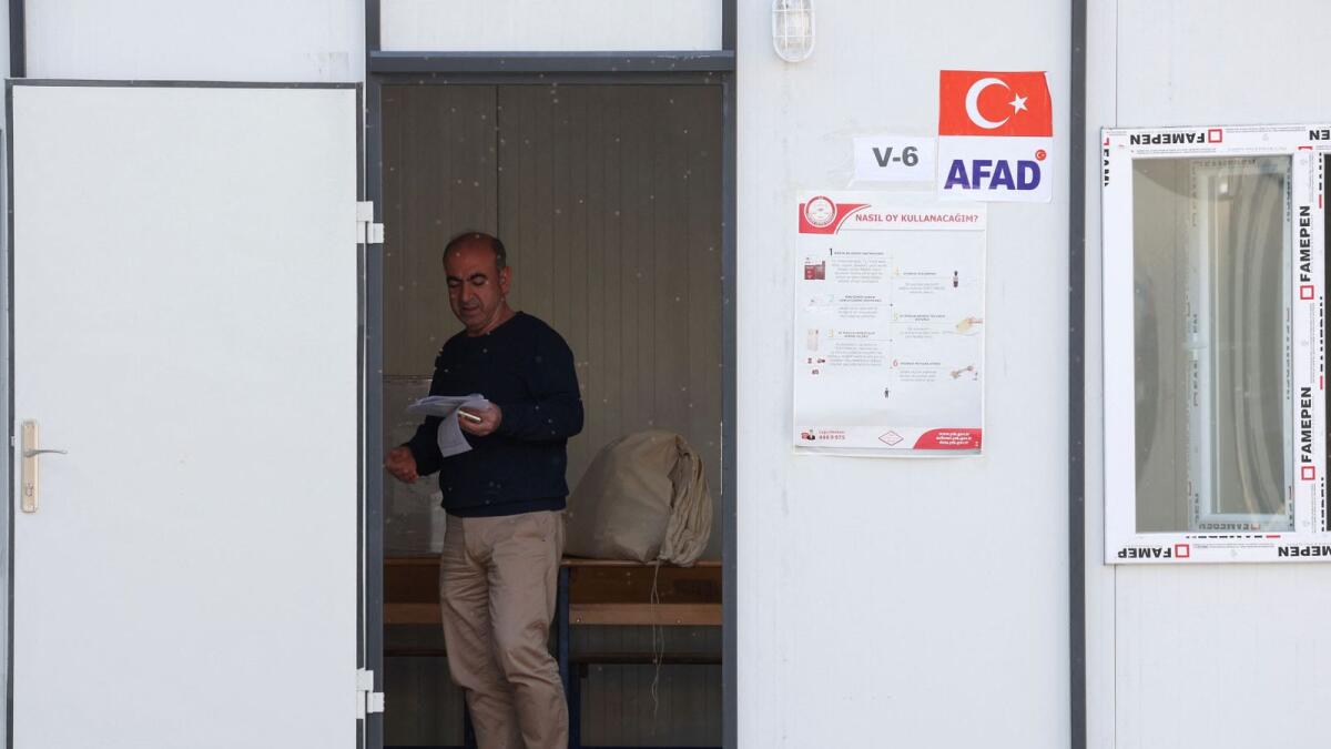 An election worker person prepares a temporary polling station in the courtyard of a damaged school on the day of the presidential and parliamentary elections, in Hatay, Turkey, on Sunday. -- Reuters