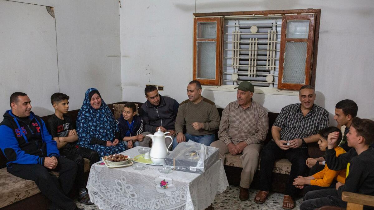 Arafat Helles, center, with his father, center right, and other family members discuss the money they will give as gifts on Eid Al Fitr, which marks the end of Ramadan, at the family home in the Shujaiyya neighborhood, east of Gaza City on April 15, 2023.  (Samar Abu Elouf/The New York Times)