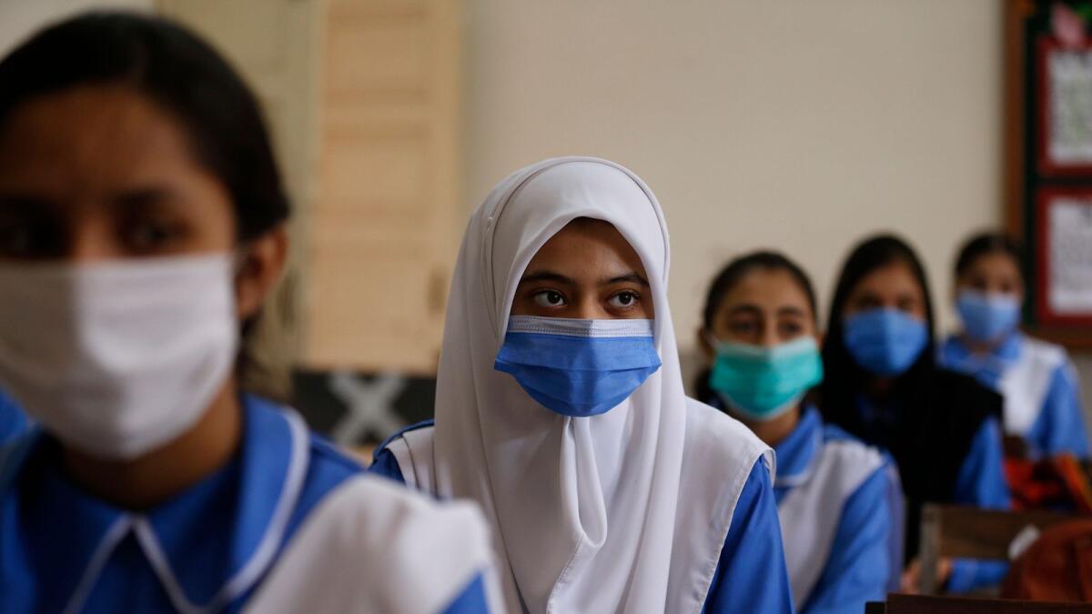 Students wearing face masks to prevent the spread of coronavirus attend their classrooms at a school in Islamabad.