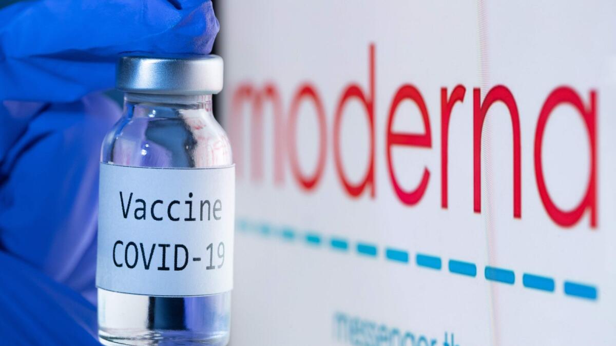 In this file photo shows a bottle reading 'Vaccine Covid-19' next to the Moderna biotech company logo. AFP