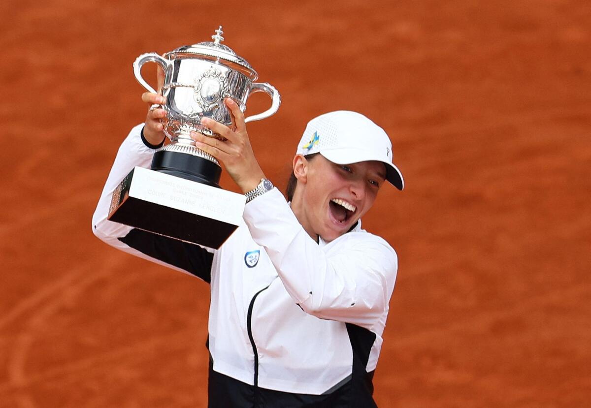 Poland's Iga Swiatek poses with the Suzanne Lenglen trophy. — Reuters
