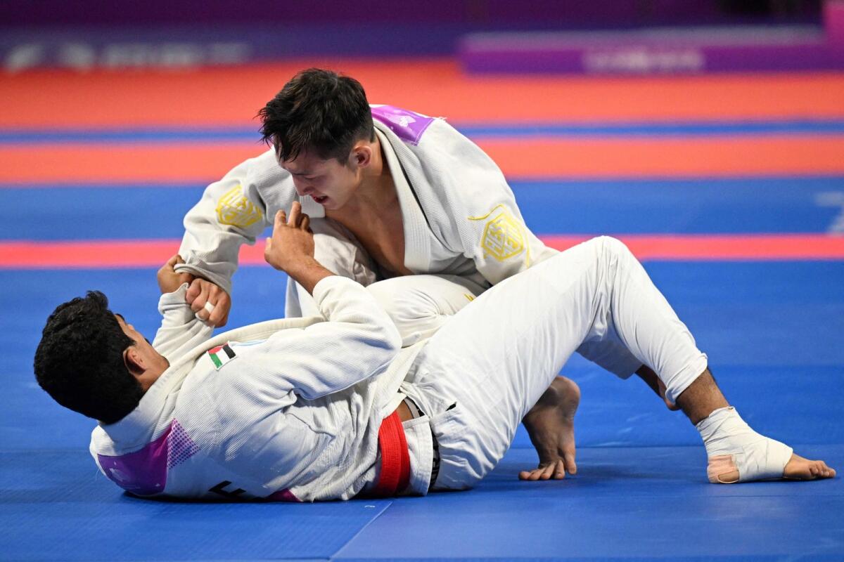 Kazakhstan's Nurzhan Batyrbekov (R) competes against United Arab Emirates' Mohamed Alsuwaidi (L) at the jiu jitsu men's 69kg event.