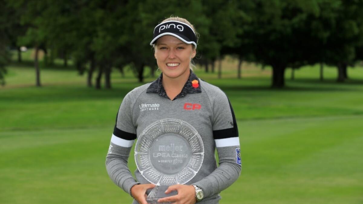 Canada's Brooke Henderson, holding last year's Meijer LPGA Classic winner's trophy, will not get to defend her crown this year. - AFP file