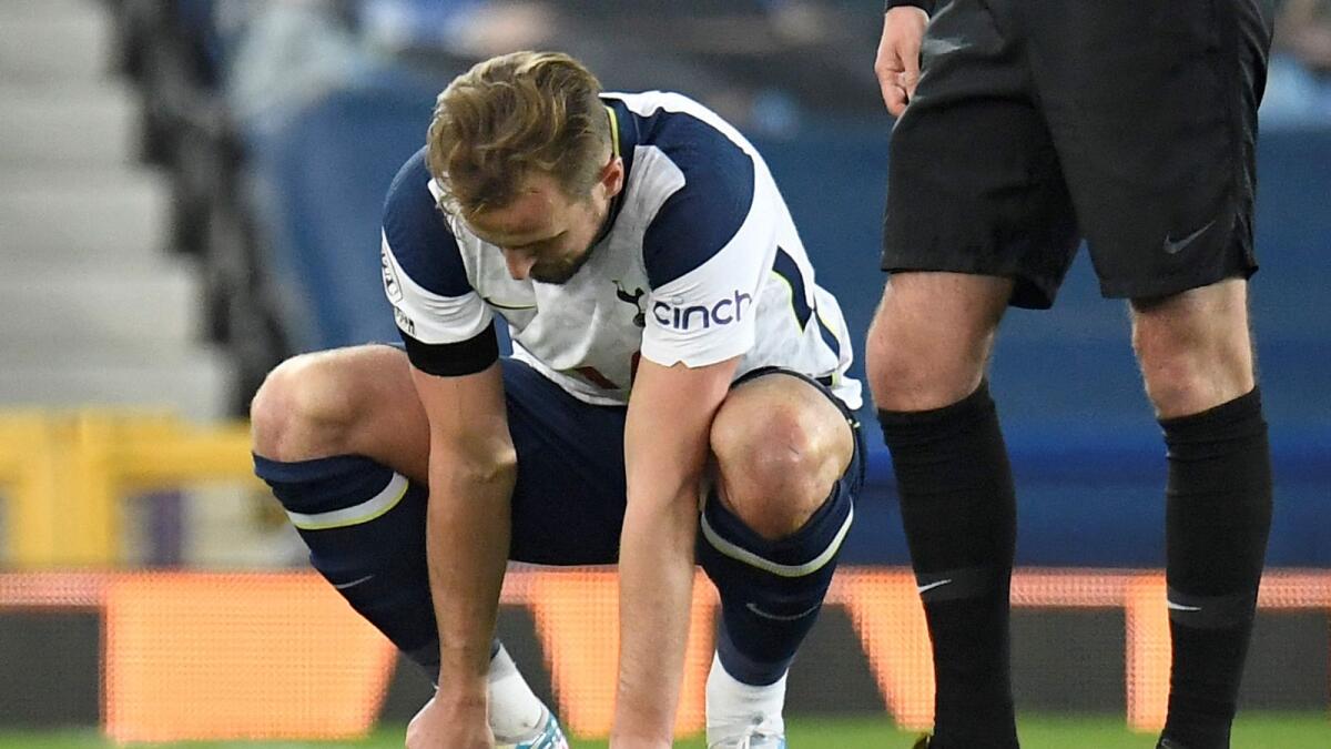 Tottenham Hotspur's English striker Harry Kane holds his foot before leaving the pitch injured during the English Premier League match against Everton. — AFP