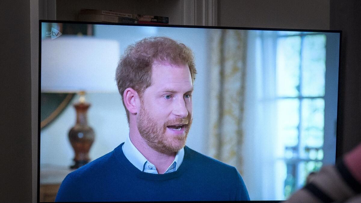 A person at home in Edinburgh watches Prince Harry being interviewed by ITV's Tom Bradby, during 'Harry: The Interview,' two days before his controversial autobiography 'Spare' is published, on Sunday, Jan. 8, 2023. — AP