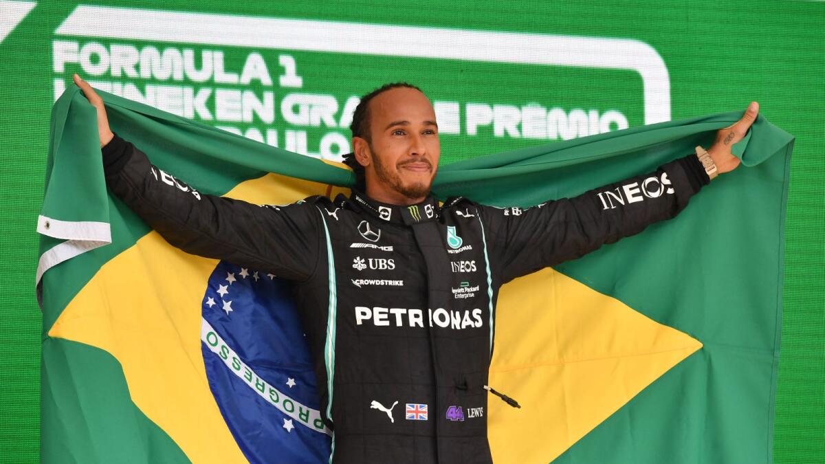 Mercedes' British driver Lewis Hamilton celebrates on the podium after winning the Brazilian Formula One Grand Prix. (AFP)