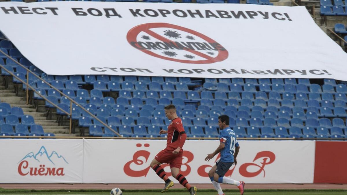 Players take part in the match, as soccer competitions in Tajikistan continue despite the global coronavirus outbreak. The banner in the stands reads: 'Stop coronavirus!' - Reuters