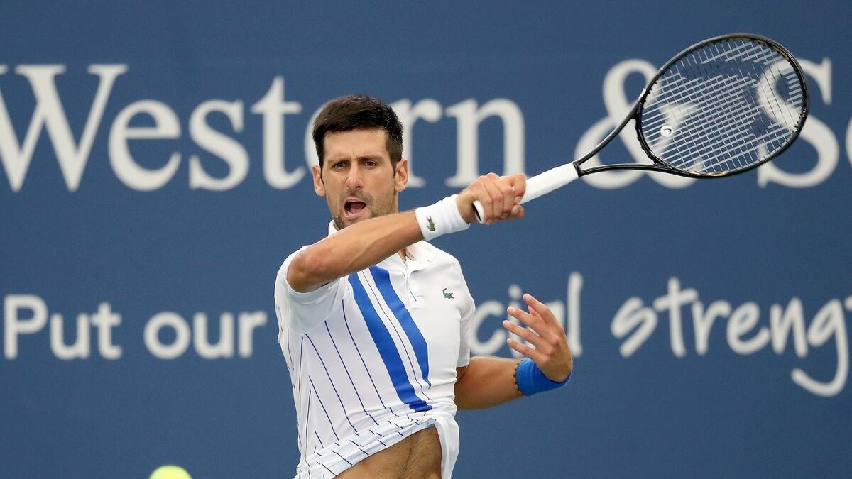 Novak Djokovic of Serbia returns a shot to Milos Raonic of Canada in the men's singles final of the Western &amp; Southern Open