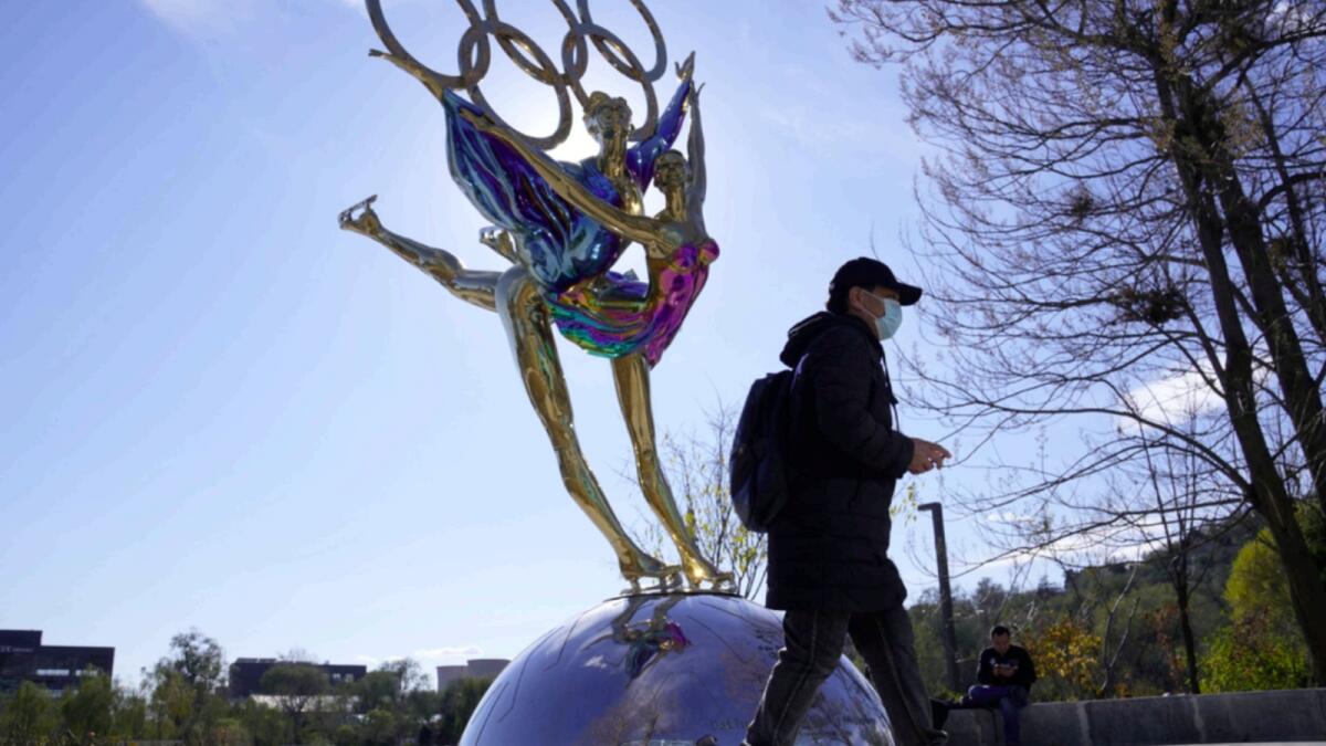 A visitor to the Shougang Park walks past the a sculpture for the Beijing Winter Olympics in Beijing. — AP