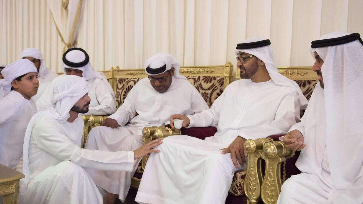Shaikh Mohammed bin Zayed  interacts with family members of martyr Rashed Al Mesafery at a condolence majlis in Ras Al Khaimah on Monday. -Wam