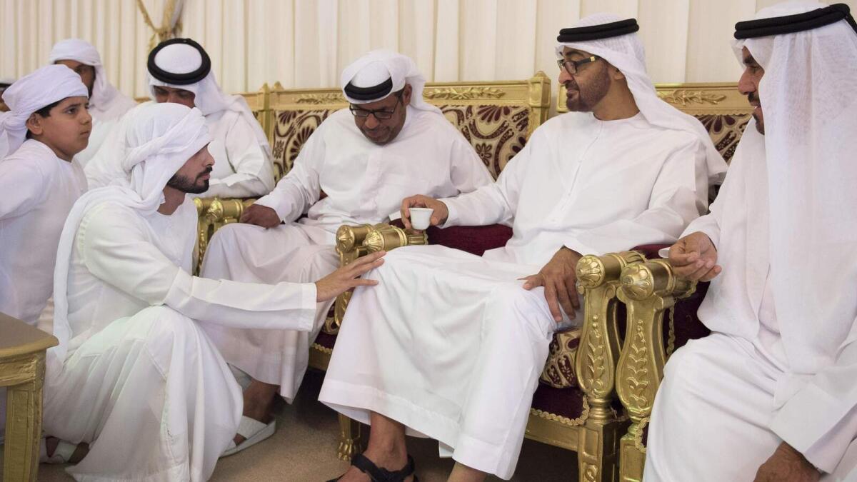 Shaikh Mohammed bin Zayed  interacts with family members of martyr Rashed Al Mesafery at a condolence majlis in Ras Al Khaimah on Monday. -Wam