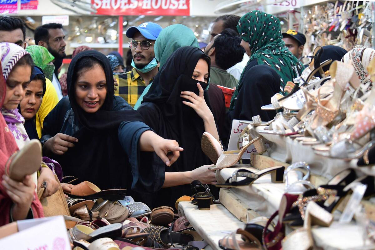 Women look at shoes at market during shopping ahead of the upcoming festival of Eid Al Fitr. Photo: AFP