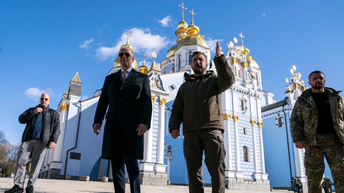 Joe Biden walks with Ukrainian President Volodymyr Zelensky at St. Michael's Golden-Domed Cathedral during an unannounced visit, in Kyiv. — AFP