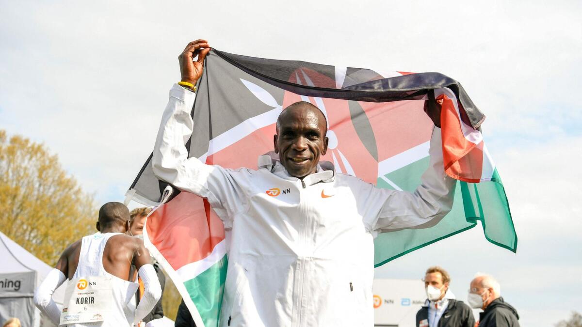 Kenya's Eliud Kipchoge celebrates with the Kenyan flag after winning the 'Hamburg Marathon' taking place at the Twente airport in Enschede, the Netherlands. — AFP