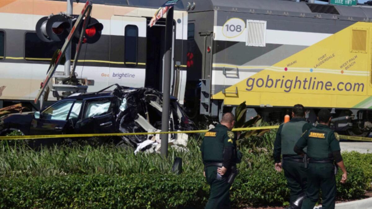 Broward County Sheriff's Office Deputies work the scene of an SUV that was struck by a Brightline train in Pompano Beach, Florida. — AP